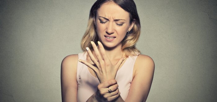 Young woman holding her painful wrist. Sprain pain.